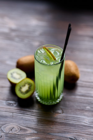 Kiwi juice in a glass on a wooden background. Selective focus.の写真素材