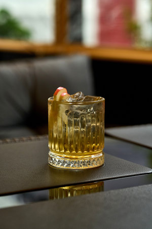 Glass of whiskey with ice cubes on a table in a restaurant.の写真素材