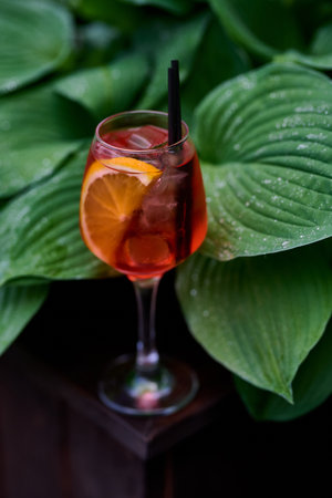 spritz cocktail with lemon and ice on a dark background