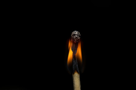 Burning match on a black background. Close-up image.の写真素材