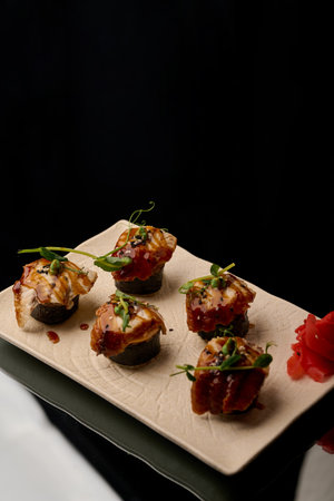 Japanese cuisine. Sushi on a plate on a black background