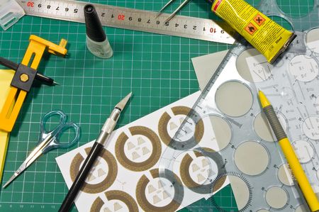 Different cutting and gluing hobby tools (rullers. knifes, paper,cardboard, cutting mat, pen,...