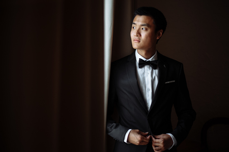 young groom stands by the window in a luxury hotelの写真素材