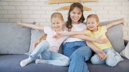 Mother tickling girls on couch