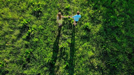 Aerial drone footage, young people run across the fieldの写真素材