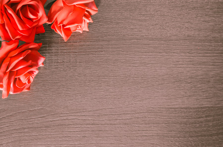 Background with some red roses on the upper left edge. Decorative background, romantic, to insert your message to the side.の写真素材