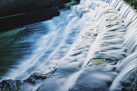 Waterfall in sequence of steps made by man on a long exposure photo. Water with smooth movement.の写真素材