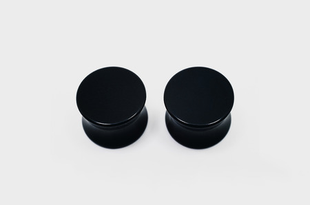 Pair of black ear plugs piercings, ear stretchers.の写真素材