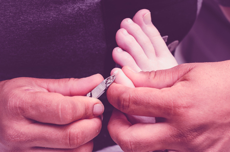 Manicurist using pliers to remove dead skin from around the client feet fingers. の写真素材