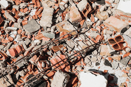 Debris of a demolished wall, demolition junk, broken concrete and pieces of masonry brick.