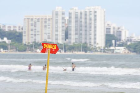 Red warning sign at the beach. Board signaling danger of rough or deep sea. の写真素材