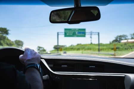 Driving a car on the highway passing by a transit sign. View through the inside of a car during a car trip on a Brazilian road.の写真素材