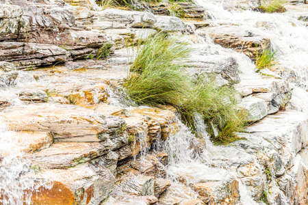 Close up view of the water falling on small cascades by the sedimentary rocks. Natural beauties of CapitÃ³lio MG, Brazil.の写真素材