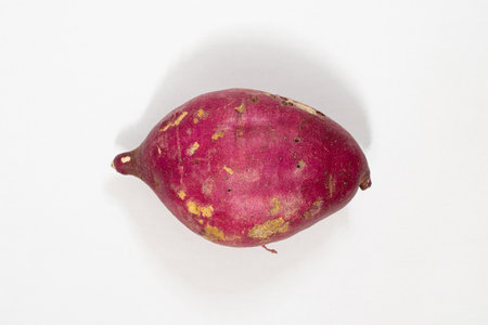 Sweet potato with damage on the skin and some holes, natural food, isolated on white background.
