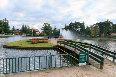 Gramado, RS, Brazil - May 16, 2022: Joaquina Rita Bier lake, an artificial lake with a small bridge, island and a fountain. Tourist destination of Gramado.のeditorial素材