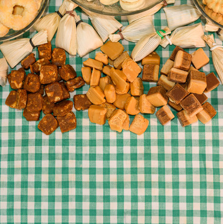 Table with typical sweets from Minas Gerais, Brazil. Sweet in corn husk, pe de moleque and milk fondant. Background with space for text.の写真素材