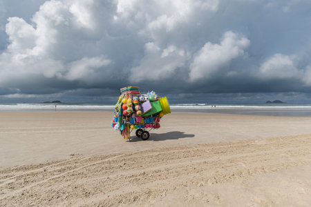 Street vendor cart selling beach items such as surfboards and children's toys on Enseada beach, Guaruja - SP, Brazil.の写真素材