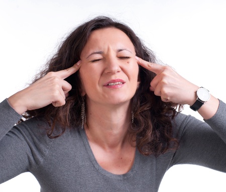 Young woman suffering from a terrible headache on a white backgroundの写真素材