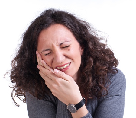 Young woman suffering from a toothache on a white backgroundの写真素材