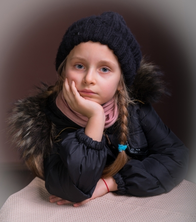 Portrait of beautiful girl in winter cloth on a brown backgroundの写真素材