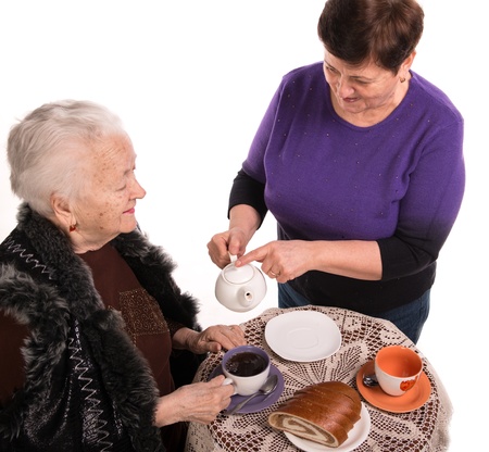 Mother having tea with her daughter on a white backgroundの写真素材