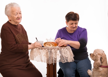 Mother having tea with her daughter on a white backgroundの写真素材
