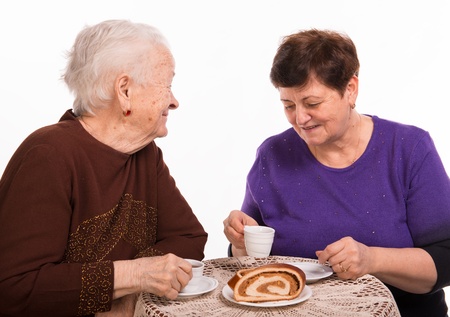 Mother having coffee with her daughter on a white background