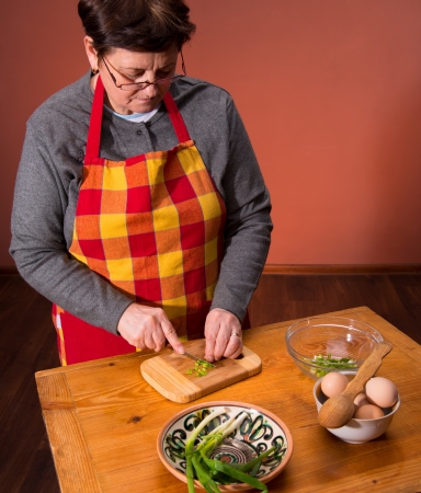 Woman preparing salad  on an orange backgroundの写真素材