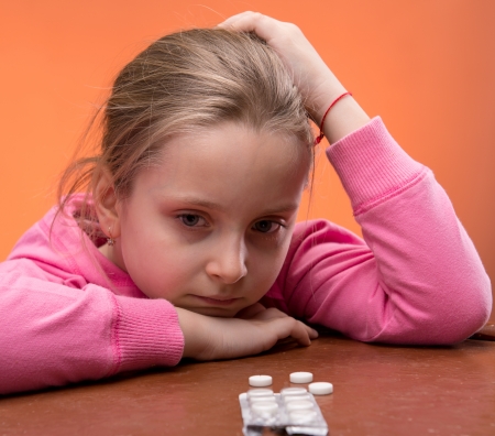 Little girl looks very upset at the thought of taking her medicineの写真素材
