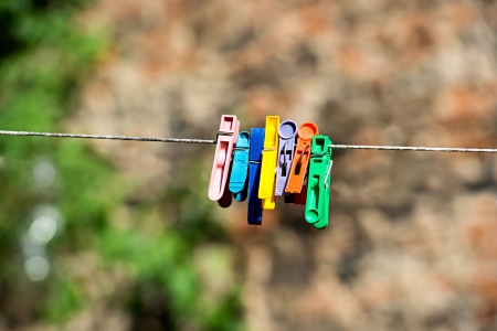 Colorful clothes pegs  hanging on a ropeの写真素材