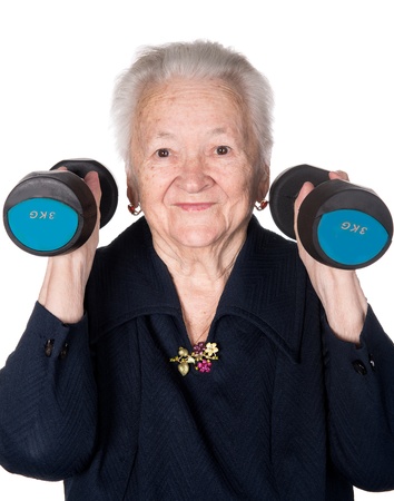 Happy old woman making fitness training with dumbbells on a white backgroundの写真素材