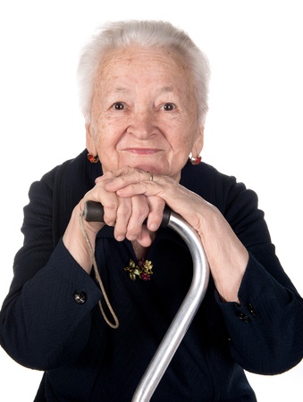 Portrait of smiling old woman sitting with a cane on a white backgroundの写真素材