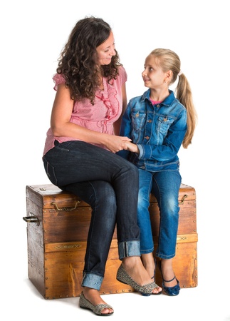 Smiling mother and daughter looking into each other on a white backgroundの写真素材