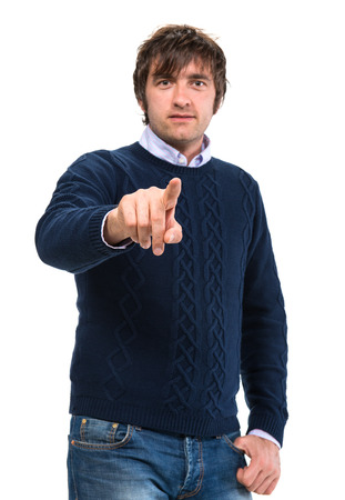 Handsome man in sweater pointing  his finger on a white backgroundの写真素材
