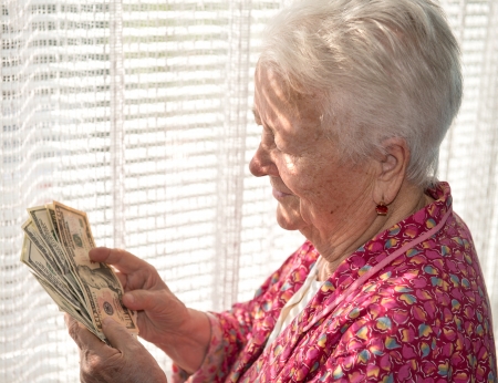 Portrait of old woman holding money in handsの写真素材