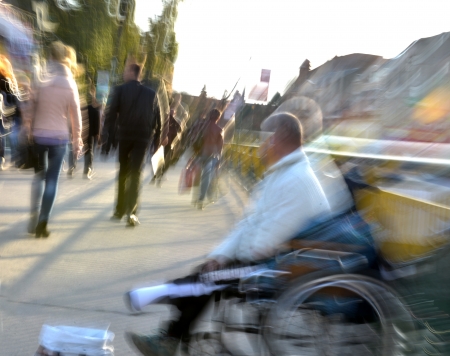 Beggar in wheelchair in motion blurの写真素材