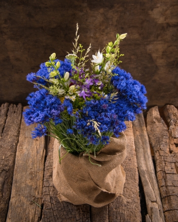 Beautiful bouquet of bright wildflowers on a wooden backgroundの写真素材