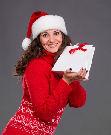 Smiling woman in santa hat with shopping bag, christmas, x-mas, winter, の写真素材