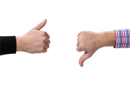 Two gesturing hands, with thumbs up and down
