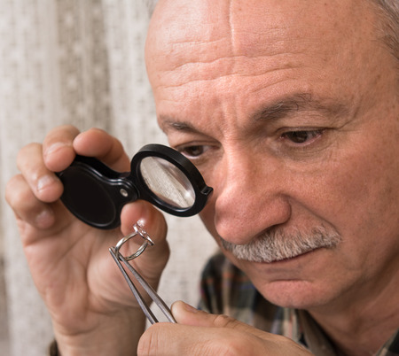 Cropped image of jeweler examining jewel 