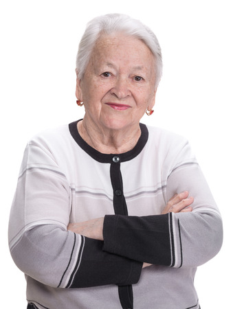 Portrait of old woman with crossed hands on a white の写真素材