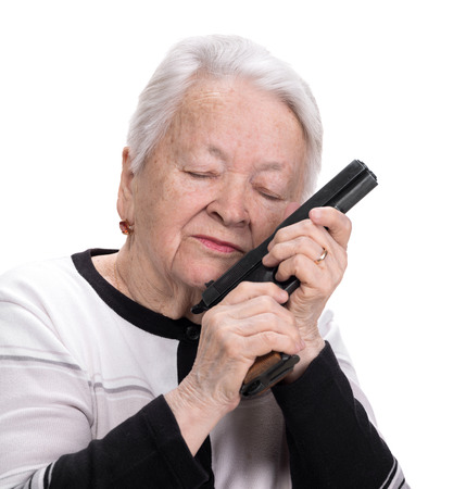 Old woman with pistol on a white backgroundの写真素材