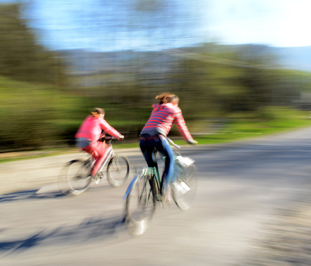 Cyclists in motion riding down the street   Intentional motion blur