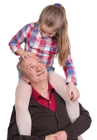 Portrait of a little girl enjoying piggyback ride with her grandfather on a white backgroundの写真素材
