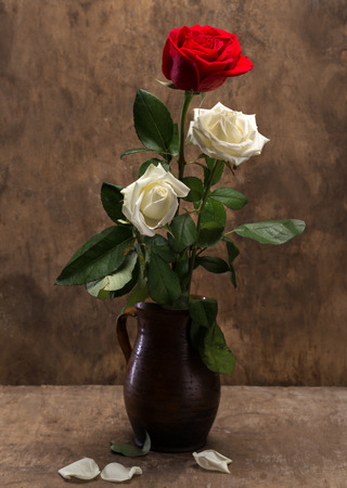 Roses in a vase on a wooden backgroundの写真素材