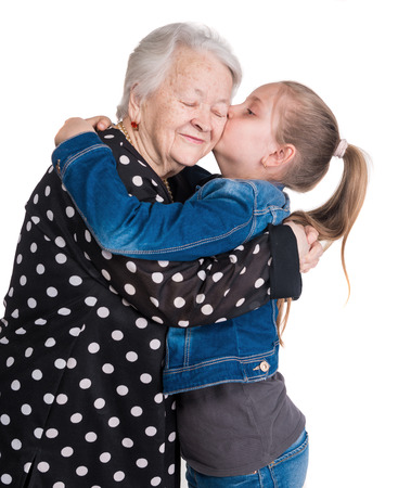 Granddaughter kissing her grandmother on white backgroundの写真素材