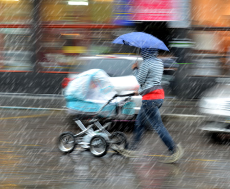 Mother walks with the child in the stroller on a rainy day  Intentional motion blurの写真素材