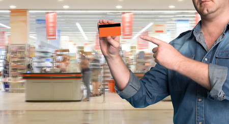 Man holding a credit card in his hand at shopping mall の写真素材
