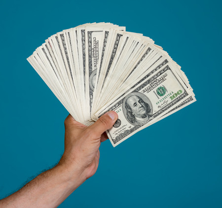 Man holding dollar bills on a blue background
