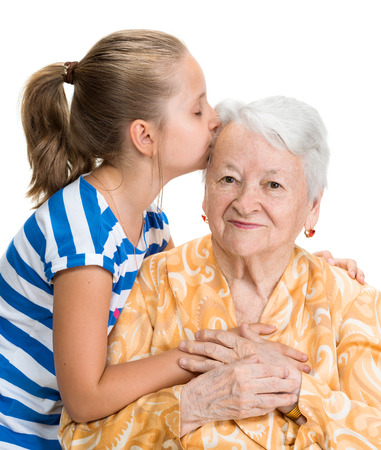 Granddaughter kissing her old grandmother on white backgroundの写真素材